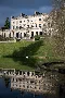 photograph of the reflection of Cowley Manor hotel in the lake