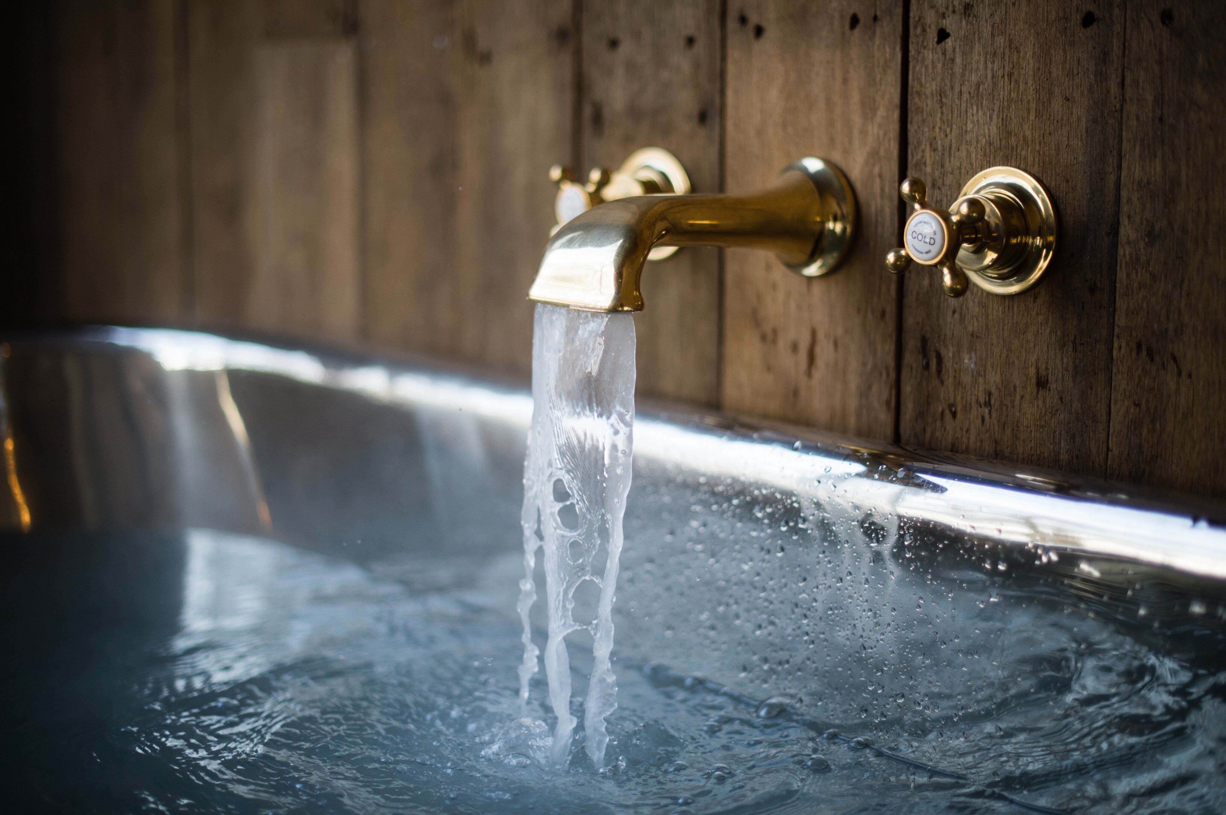 brass bath taps of outdoor bath at Limewood hotel in the new forest